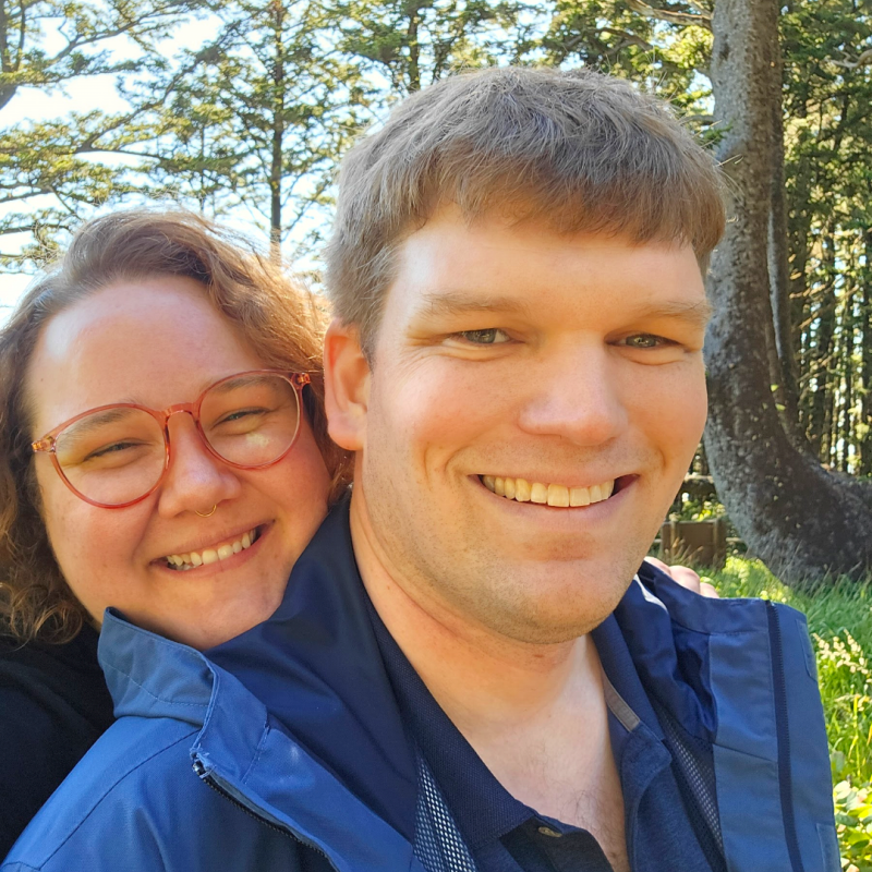 Jason and his wife smiling on a hike. 